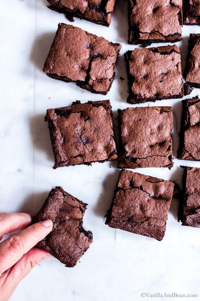 Multiple espresso brownies with a hand taking one.