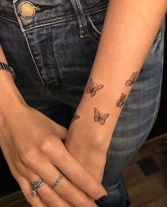 Minimalist butterfly tattoo on the right ring finger