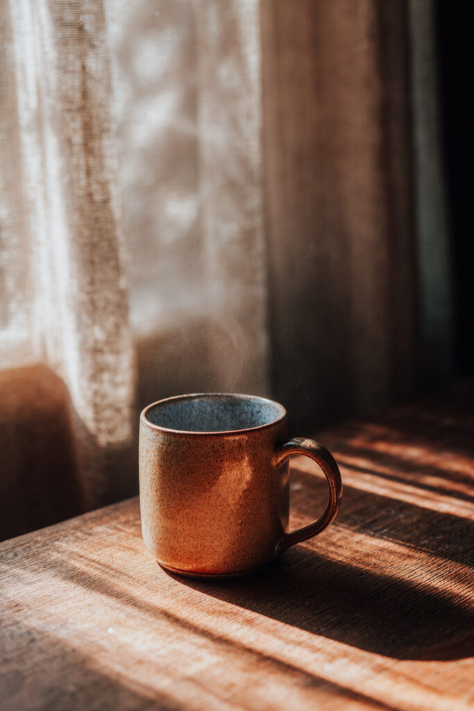 Morning mug by window with natural light photography at home.