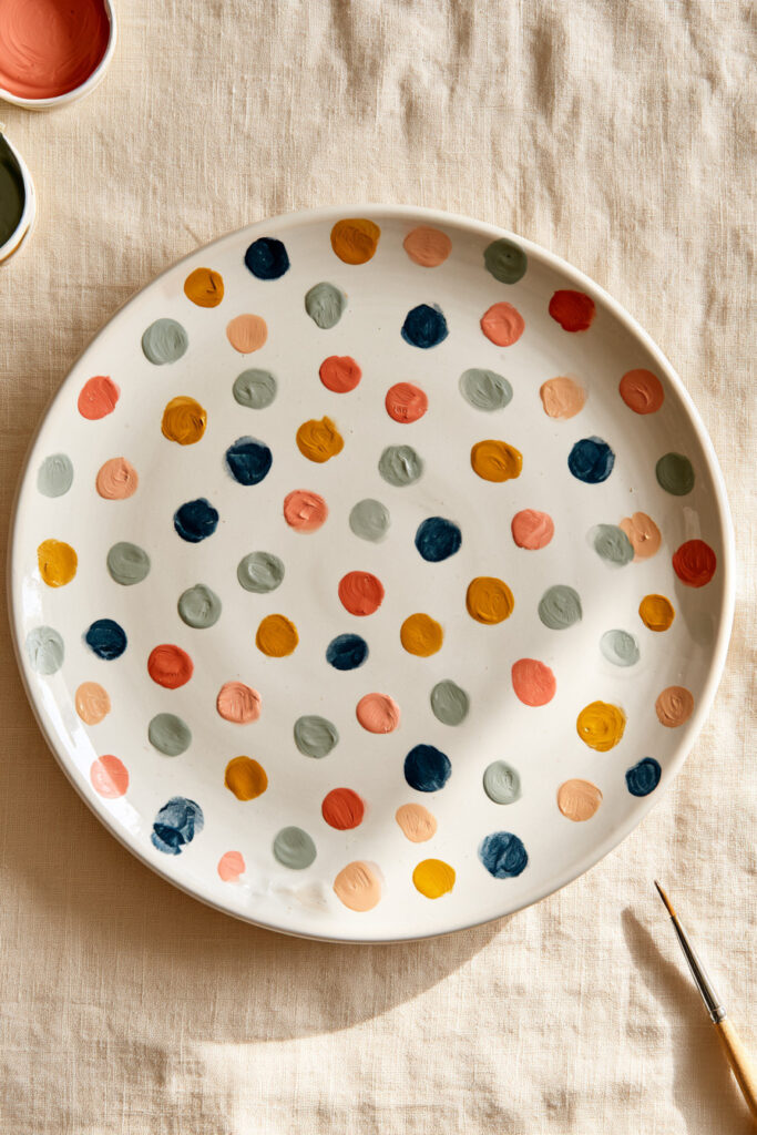 White ceramic plate covered with colorful painted dots