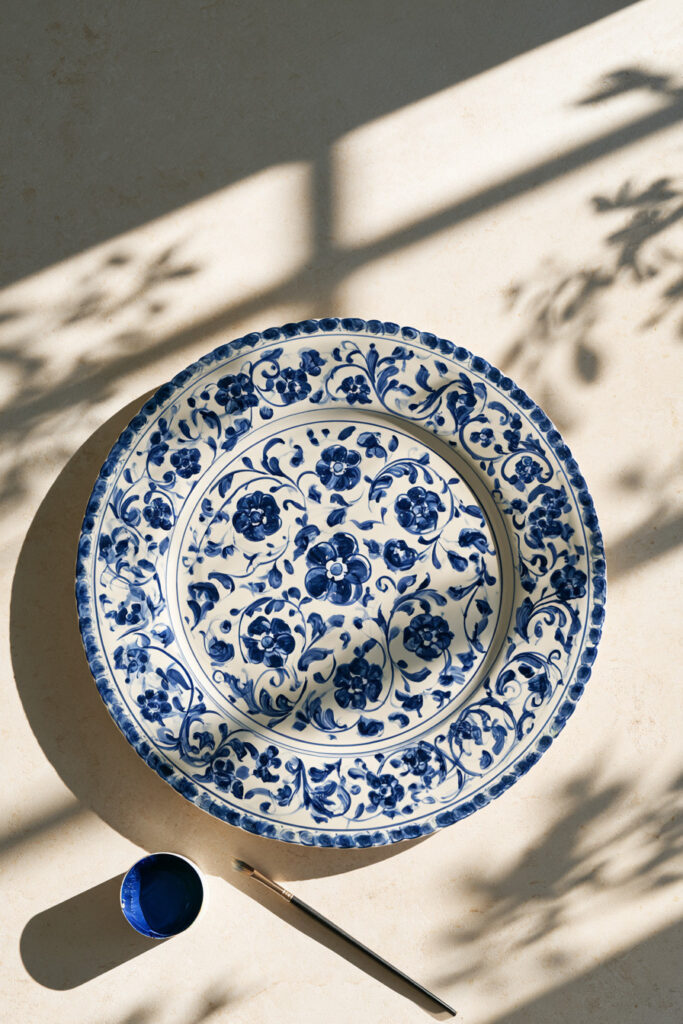 White ceramic plate painted with a Mediterranean blue geometric and botanical border