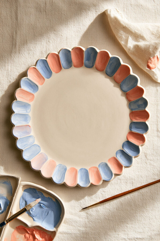 White ceramic plate painted with a simple blue scalloped border