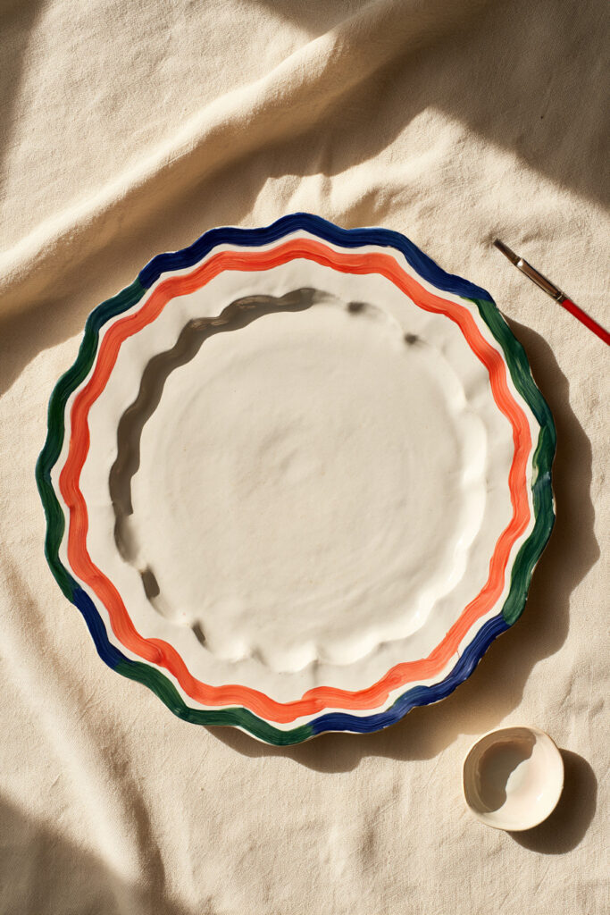 White ceramic plate painted with a loose cobalt blue wavy rim